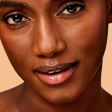 Close-up of woman face with glossy skin and lips